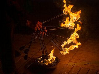 Manos encendiendo con llamas, antorchas de malabares, para actuar en una fiesta, Barcelona 2022
