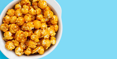 Honey caramel popcorn on blue background.
