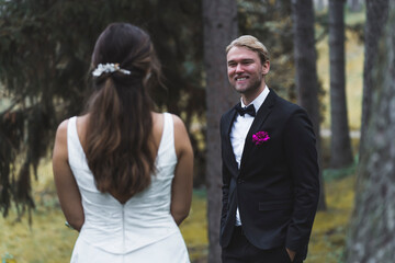 Family of two - just married heterosexual ethnic spouses. Happy laughing handsome Scandinavian husband looking in amusement and love at his beautifully dressed Turkish bride standing back to the