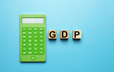 A picture of wooden block written GDP or short form of Gross Domestic Product with calculator insight