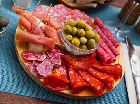 Appetizer of various types of Spanish sausages on platter served to wine