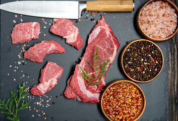 Organic raw meat, beef or lamb on dark stone and spices. top view.