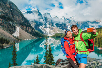 Moraine lake Couple tourists taking selfie picture on Canada travel hike using phone. Young hikers...
