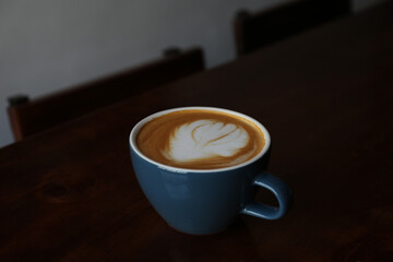 Cup of aromatic coffee on wooden table in cafe