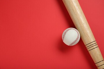 Wooden baseball bat and ball on red background, flat lay. Space for text