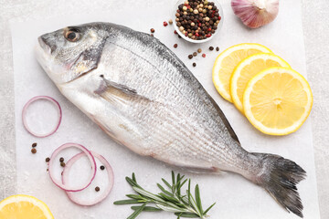 Flat lay composition with fresh raw dorado fish and ingredients on light grey table