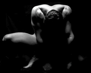 muscular male fitness model in dramatic silhouette pose, naked man displays athletic fit body with...