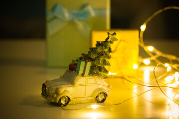 Retro vintage toy car with New Year tree on a roof. Gifts delivery for Christmas winter holidays....