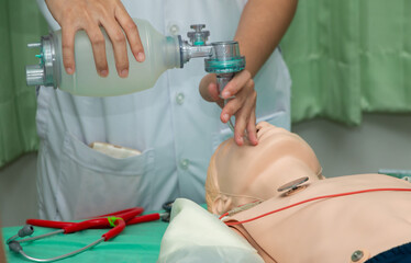 Demonstrating CPR (Cardiopulmonary resuscitation) training medical procedure on CPR doll in the...