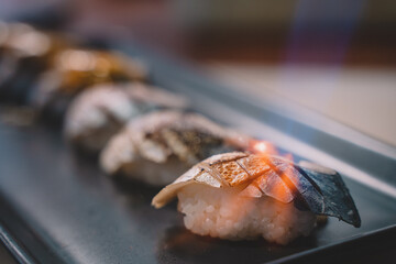 The chef is burning salmon, fish, crab, tuna and squid sushi. sushi is a street food of japan and new business in the world.