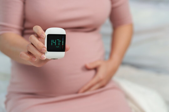 pregnant woman holding glucose meter with result of measurement sugar high level. gestational diabetes concept.