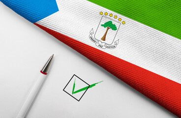 pencil, flag of Equatorial Guinea and check mark on paper sheet
