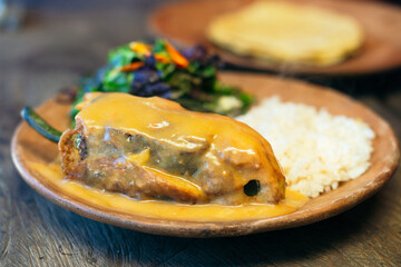 Chile relleno with rice, beans, tortillas and salad on a plate.Lunch.