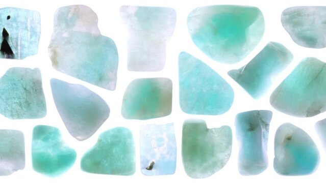 Isolated amazonite gem stone texture. Rare mineral pebbles background. Moving right seamless loop backdrop.