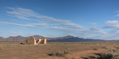 Ruined building in an Australian landscape with mountains in the distance