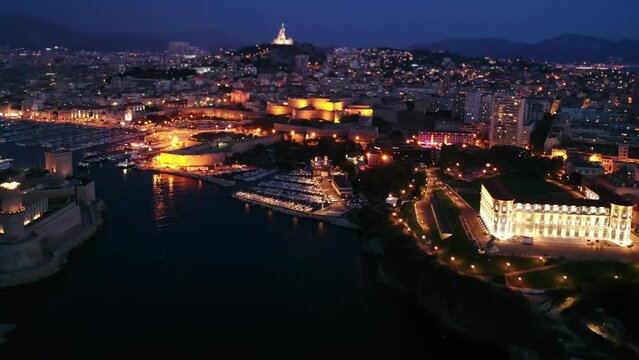 Bir's eye view of Marseille in evening with turned on city lights. Palais du Pharo visible from above.