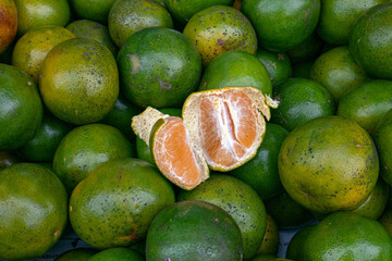 A pile of green oranges in the supermarket