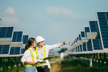 Asian Young Inspector Engineer man and female walking checking operation in solar farm
