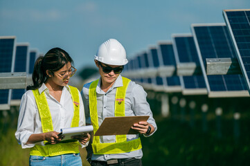 Asian Young Inspector Engineer man and female walking checking operation in solar farm