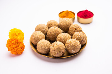 tilgul or til gul laddu or Sesame seed jaggery ball or til ke laddo with flower and haldu kumkum