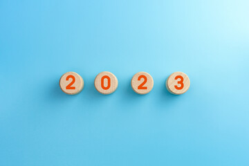 Wooden cubes with 2023 icon on blue background