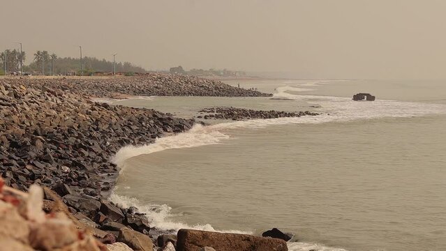 waves crashing on sea beach of digha india during dusk or dawn. Rocks and boulders are seen on the beach.