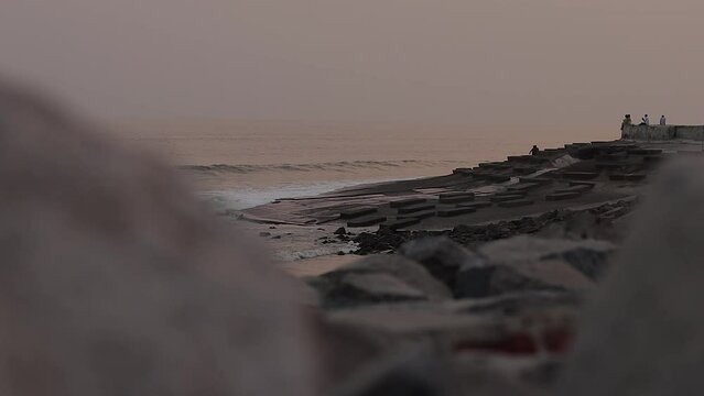 waves crashing on sea beach of digha india during dusk or dawn. Rocks and boulders are seen on the beach.