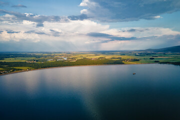 Aerial top view of beautiful landscape with large lake against mountains shapes at summer day. Mietkow lake near Wroclaw, Poland
