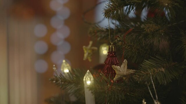 Weihnachtsschmuck wird an den Christbaum geh&auml;ngt
