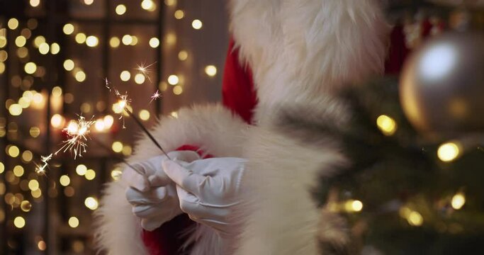Santa Claus is holding sparklers in his hands. Christmas mood.