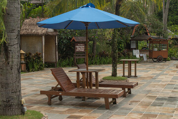 vacation by the pool with wooden chairs and umbrellas