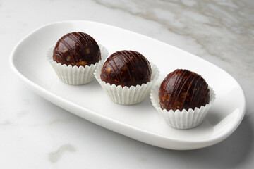 Three chocolate candies sweets on white plate
