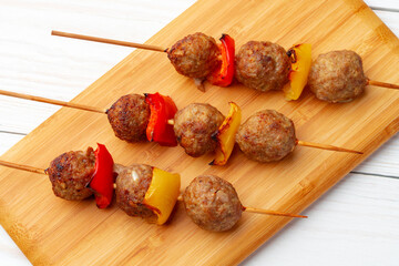 Bbq kebabs on the skewers served on wooden board.