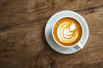 Cup of hot latte art coffee on the wooden table. morning drink concept