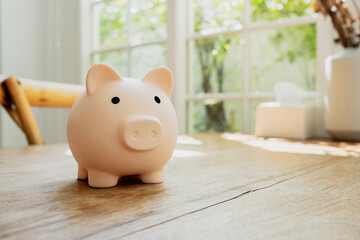 Piggy bank on a wooden table with blue background. saving money and invest concept.