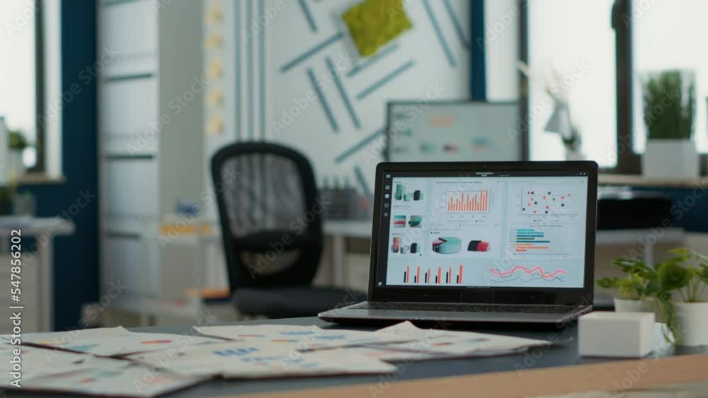 Poster empty startup office with laptop showing business mangement software on display showing moving chart