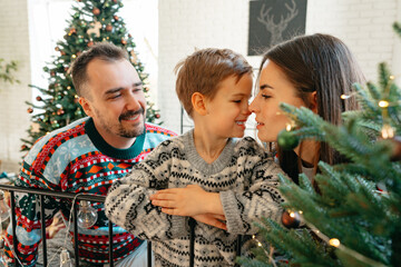 Happy family near fir-tree in bedroom, Christmas celebration at home