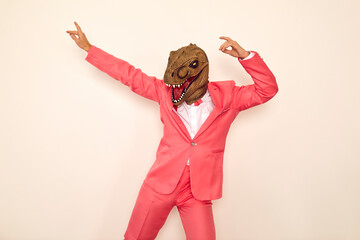 Weird crazy guy in wacky dinosaur mask enjoying free time and having fun at party. Happy confident...
