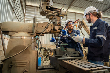 Team of engineers practicing maintenance Taking care and practicing maintenance of old machines in the factory so that they can be used continuously.