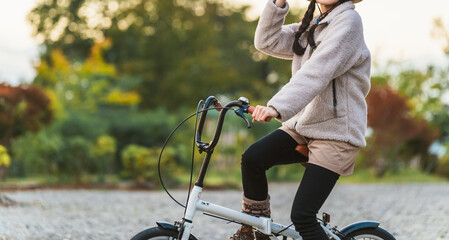 アウトドア系のファッションで夕方自転車に乗るアジア人女性（サイクリング）
