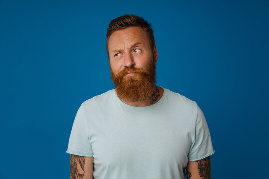 Portrait of adult bearded tattooed handsome stylish sceptic man
