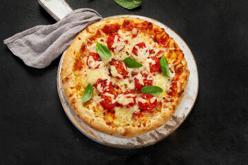 Freshly baked pizza on dark background.