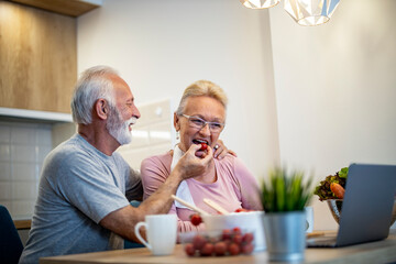 Senior couple at home preparing salads