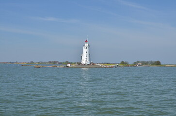 Fototapeta na wymiar lighthouse in netherlands at seablue sky water