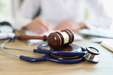 Judge hammer and doctor stethoscope on office desk