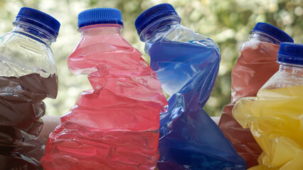 Colorful skewed bottles on nature background.