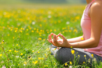 Close up of a woman doing yoga exercise in a field