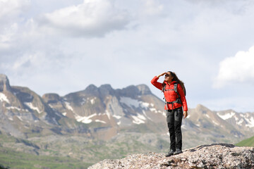 Fototapeta na wymiar Hiker in red searching in the mountain