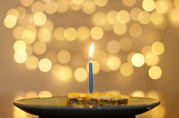 Festive birthday cake with burning candles against bright bokeh background. Greeting card. Party and holiday celebration concept