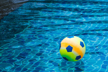 Fototapeta na wymiar Inflatable colorful ball floating in a swimming pool.